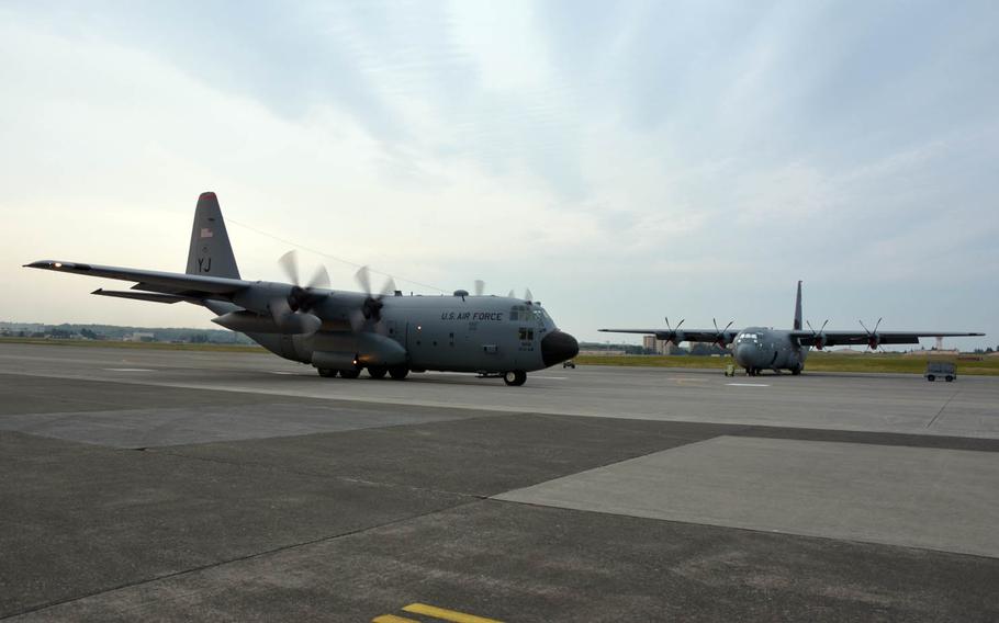 An older C-130H Hercules cargo plane, left, passes a newer C-130J Super Hercules at Yokota Air Base, Japan, Thursday, April 20, 2017.