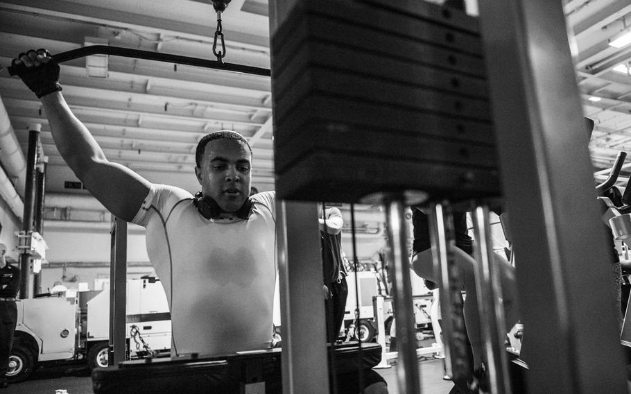 Petty Officer 2nd Class Robert Gardner, an aviation machinist's mate on board the aircraft carrier USS George H.W. Bush, performs the military press while working out during a deployment in the Persian Gulf, April 19, 2017.