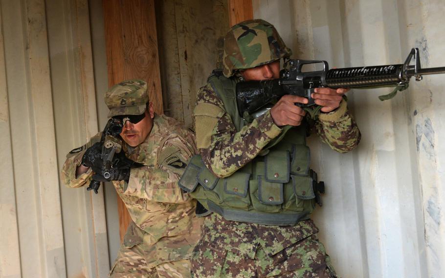 A U.S. Army adviser from Task Force Forge conducts a room clearing drill with an Afghan trainee to demonstrate proper tactial procedures at the Regional Military Training Center in Helmand Province, Afghanistan, March 8, 2017. 