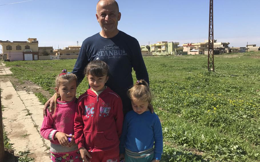 Adlil Slewa stands with his daughters - from left, Oleana, 6, Samantha, 7, and Renata, 4 - near their home in the village of Teleskof, Iraq, on March 24, 2017. The family returned in late March after nearly three years of Islamic State occupation to find their belongings destroyed or stolen. Dozens of residents have returned to this village near Mosul, where a U.S. Navy SEAL was killed in 2016.