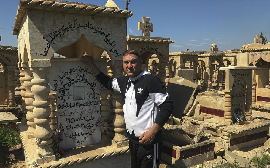 Manhel Mat Yousef stands beside his mother's grave in the cemetery of the Iraqi village Teleskof on March 24, 2017. Yousef said he lost his home, several family members and his job to terrorism and violence in Iraq. He said he wants to leave the country.