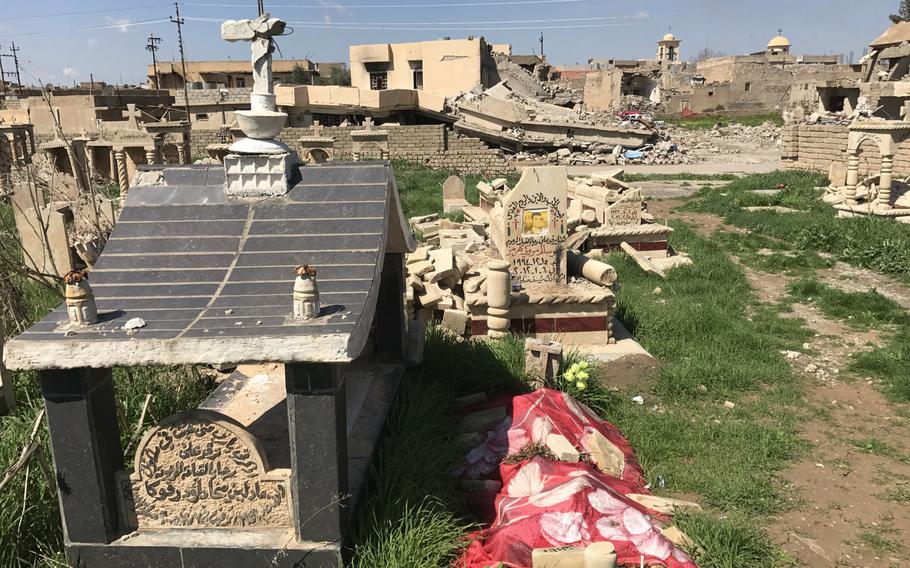 Damaged graves in the cemetery in Teleskof, Iraq, are pictured here on March 24, 2017. In the background are homes damaged in the fighting for this village over the past nearly three years between Islamic State and Kurdish forces. Now liberated, the village is finally starting to be reinhabited.