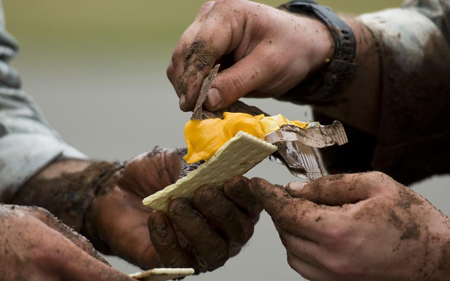Senior Airman Ryan Daggett, right, and Staff Sgt. Jordan Lucey, from the 435th Security Forces Squadron, spread cheese on a cracker from a Meal Ready to Eat during the 435th Contingency Response Group Olympics at Ramstein Air Base, Germany, on Friday, May 5, 2017.