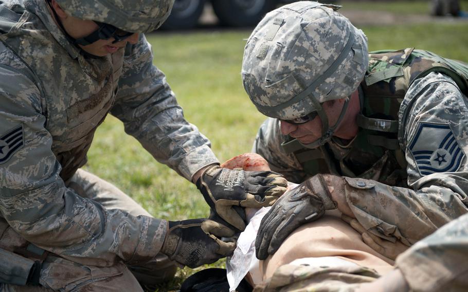 Master Sgt. David Thomas, right, and Staff Sgt. Adam Borjon from the 435th Construction and Training Squadron, treat a simulated patient during the 435th Contingency Response Group Olympics at Ramstein Air Base, Germany, on Friday, May 5, 2017.