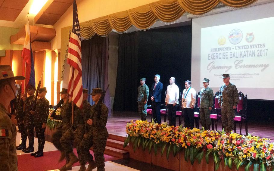 Troops march with U.S. and Philippines flags in front of military and civilian leaders to kick off annual Balikatan military drills at Camp Aguinaldo, Philippines, Monday, May 8, 2017.