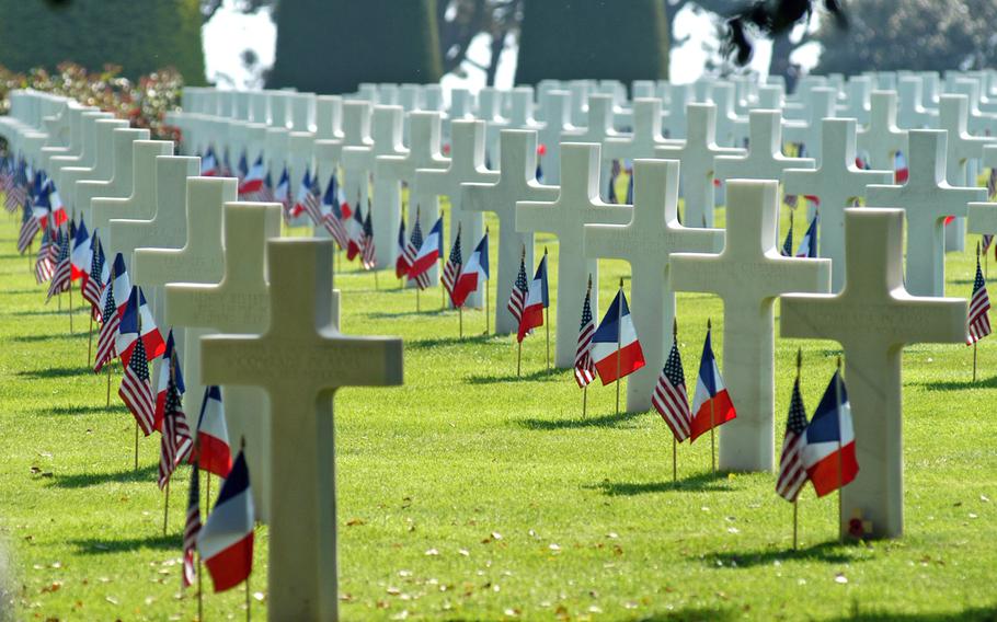 Rows of crosses and Stars of David stand in long rows at Normandy American Cemetery, Colleville-sur-Mer, France, decorated with American and French flags. The cemetery is the final resting place for 9,387 of our war dead. Visit one of the Memorial Day services at an American Battle Monuments Commission this Memorial Day weekend.