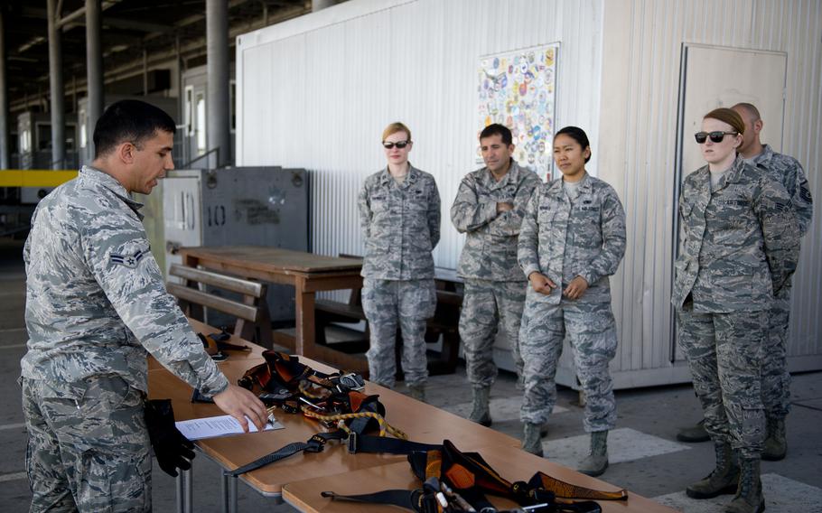 Airman 1st Class Hector Montoya describes to fellow 721st Aerial Port Squadron members how to properly inspect and wear harnesses during annual fall protection training at Ramstein Air Base, Germany, on Wednesday, May 10, 2017.