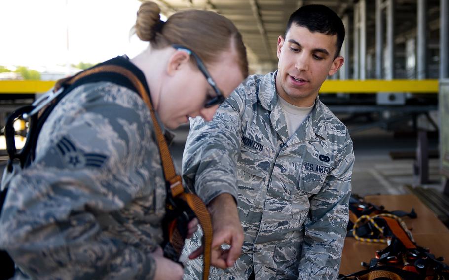 Airman 1st Class Hector Montoya, right, helps Senior Airman Sarah Isbell adjust a harness during the 721st Aerial Port Squadron's annual fall protection training at Ramstein Air Base, Germany, on Wednesday, May 10, 2017.