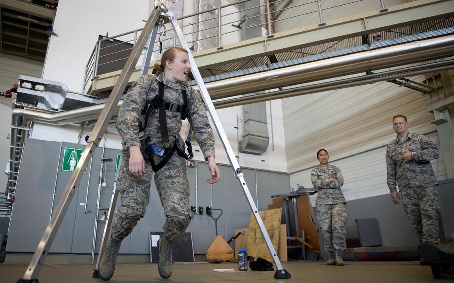 Senior Airman Sarah Isbell hangs in a harness during the 721st Aerial Port Squadron's annual fall protection training at Ramstein Air Base, Germany, on Wednesday, May 10, 2017. APS personnel took turns hanging in the harness to feel the effects of a fall.