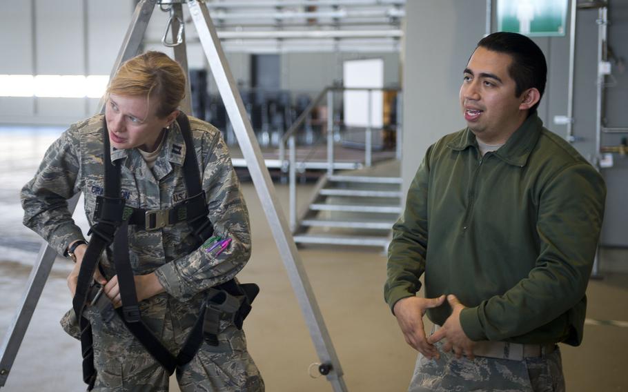 Staff Sgt. Ulysses Arango, right, describes the different types of harnesses as Capt. Teresa Crampton tightens her straps during fall protection training at Ramstein Air Base, Germany, on Wednesday, May 10, 2017. Arango is from the 721st Aircraft Maintenance Squadron and Crampton is from the 721st Aerial Port Squadron.