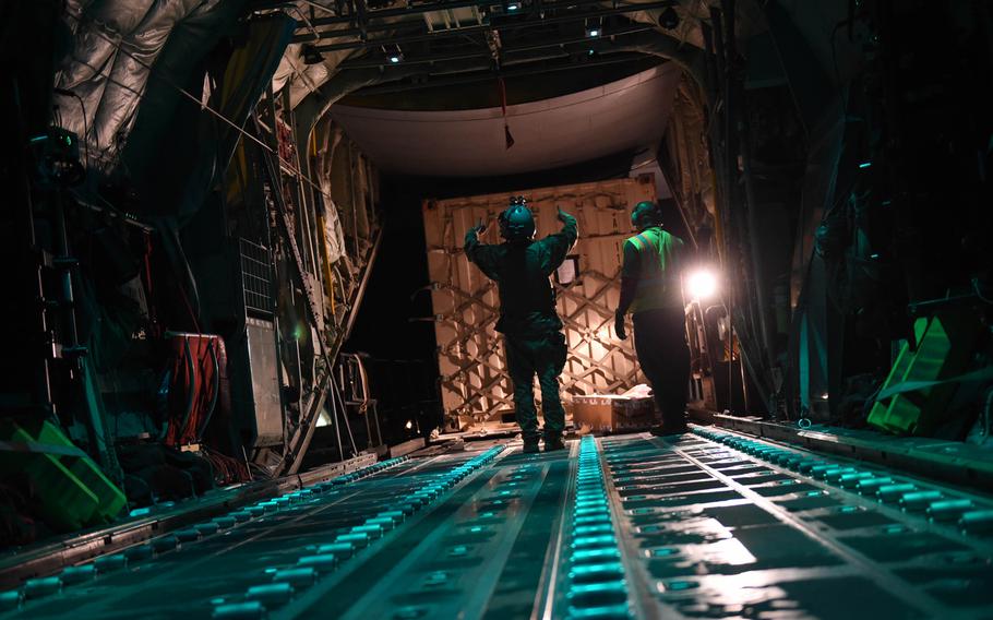 Senior Airman Ryan Berry, 26, of Bedford, Texas, waves a pallet onto a C-130J at Camp Dwyer, Afghanistan, May 5, 2017. Because Dwyer is less secure than Bagram or Kandahar, Berry must keep his body armor and helmet on when unloading and loading cargo.