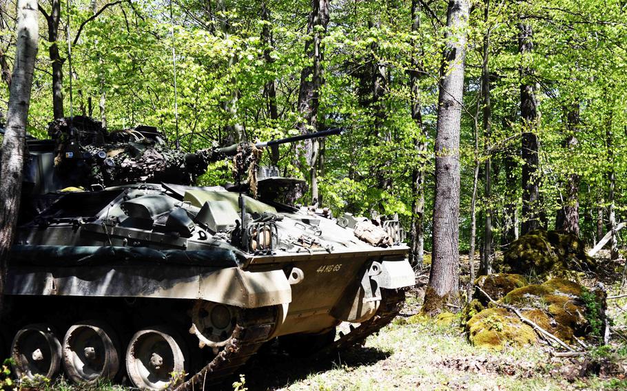 A British Warrior Observation Post Vehicle waits in the woods in Hohenfels, Germany, concealed from simulated enemy forces during Exercise Saber Junction, Wednesday, May 10, 2017.