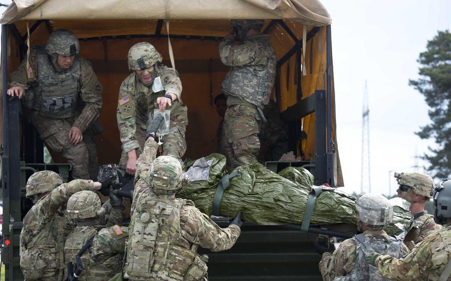 Soldiers from the 5th Battalion, 7th Air Defense Artillery Regiment take a simulated casualty off of a truck during a casualty evacuation exercise at Rhine Ordnance Barracks, Germany, on Thursday, May 11, 2017.