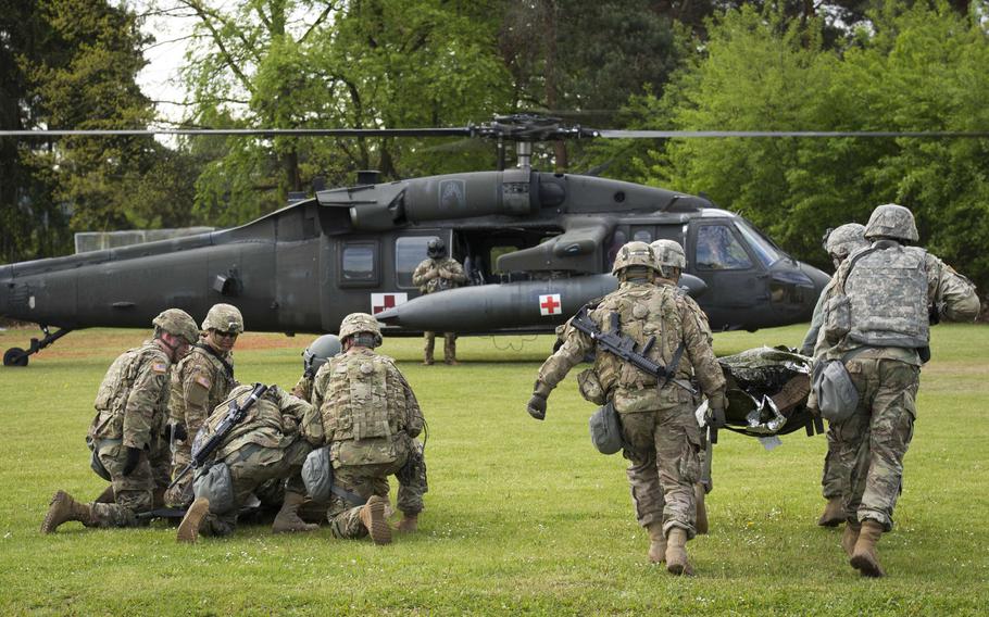 Soldiers from the 5th Battalion, 7th Air Defense Artillery Regiment prepare to load simulated casualties onto a Black Hawk helicopter during a casualty evacuation exercise at Rhine Ordnance Barracks, Germany, on Thursday, May 11, 2017.
