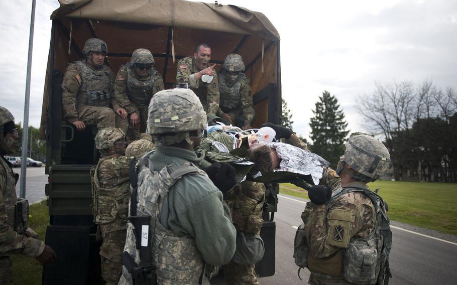 Soldiers from the 5th Battalion, 7th Air Defense Artillery Regiment take a simulated casualty off of a truck during an exercise at Rhine Ordnance Barracks, Germany, on Thursday, May 11, 2017.