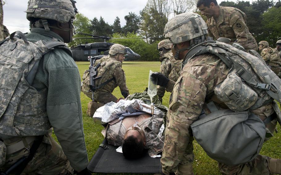 Soldiers from the 5th Battalion, 7th Air Defense Artillery Regiment prepare to load a simulated casualty onto a 12th Combat Aviation Brigade Black Hawk helicopter during a casualty evacuation exercise at Rhine Ordnance Barracks, Germany, on Thursday, May 11, 2017.