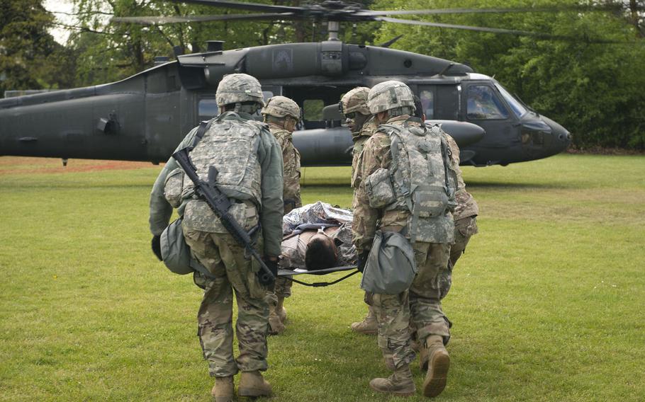 Soldiers from the 5th Battalion, 7th Air Defense Artillery Regiment prepare to load a simulated casualty onto a Black Hawk helicopter during an exercise at Rhine Ordnance Barracks, Germany, on Thursday, May 11, 2017.