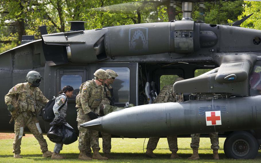 Soldiers load a simulated casualty onto a Black Hawk helicopter during an exercise at Rhine Ordnance Barracks, Germany, on Thursday, May 11, 2017.