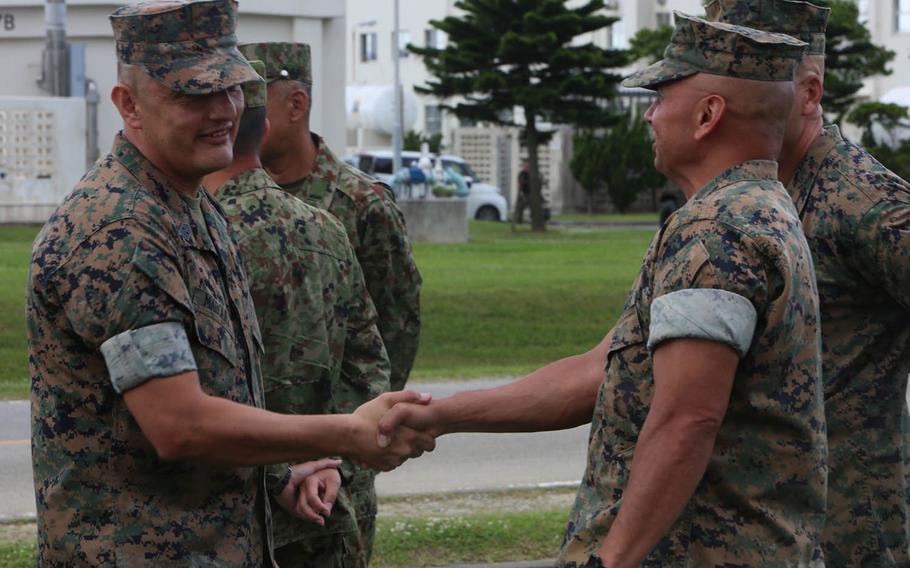 Sgt. Maj. Mario Marquez, left, greets III Marine Expeditionary Force Marines during a ceremony at Camp Hansen, Okinawa, Friday, May 12, 2017. Marquez replaced Sgt. Maj. Lee Bonar Jr. as the III Marine Expeditionary Force sergeant major.