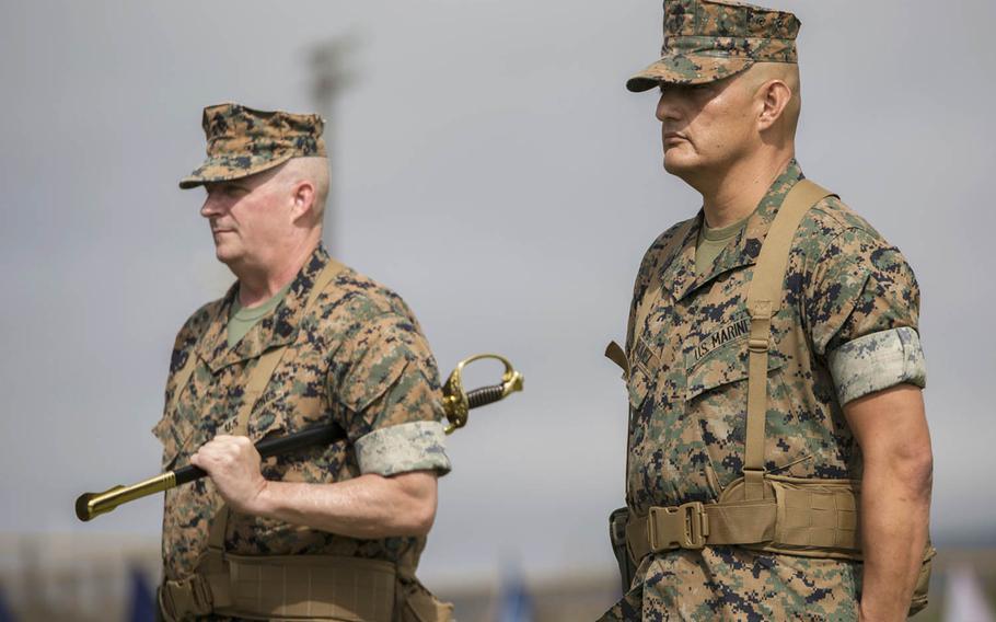 Sgt. Maj. Mario Marquez, right, stands ready to receive the noncommissioned officer sword, symbolizing his appointment as III Marine Expeditionary Force sergeant major, during a ceremony at Camp Hansen, Okinawa, Friday, May 12, 2017. Sgt. Maj. Lee Bonar Jr., left, relinquished his post to Marquez and retired after nearly 33 years of service.