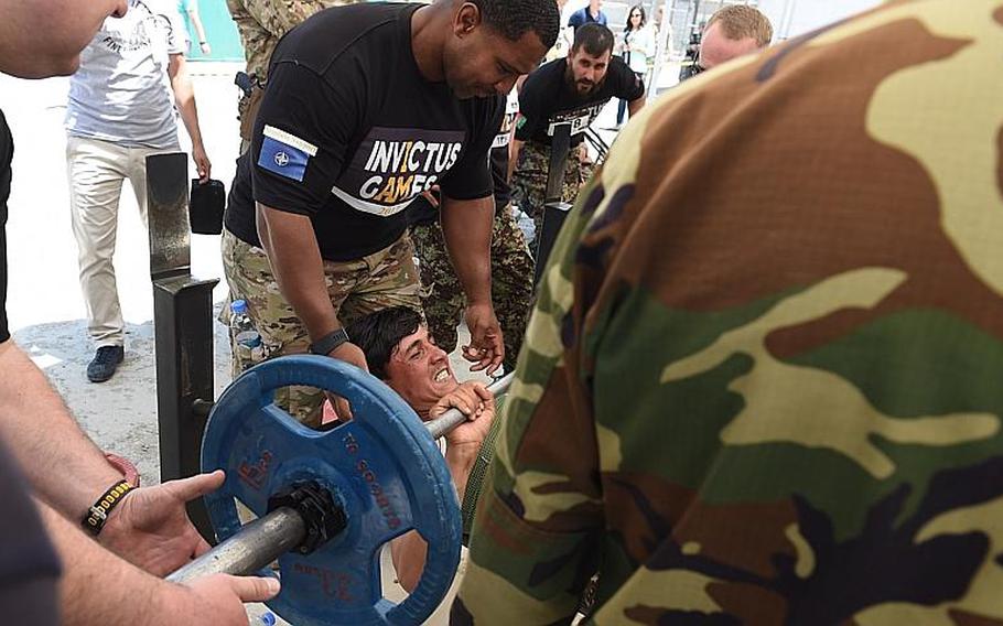 Senior Master Sgt. Herbert Hayes, who works in airspace management at Resolute Support headquarters, assists an Afghan soldier competing for a slot on Afghanistan?s team for the 2017 Invictus Games, in Kabul, Afghanistan, Saturday, May 13, 2017.