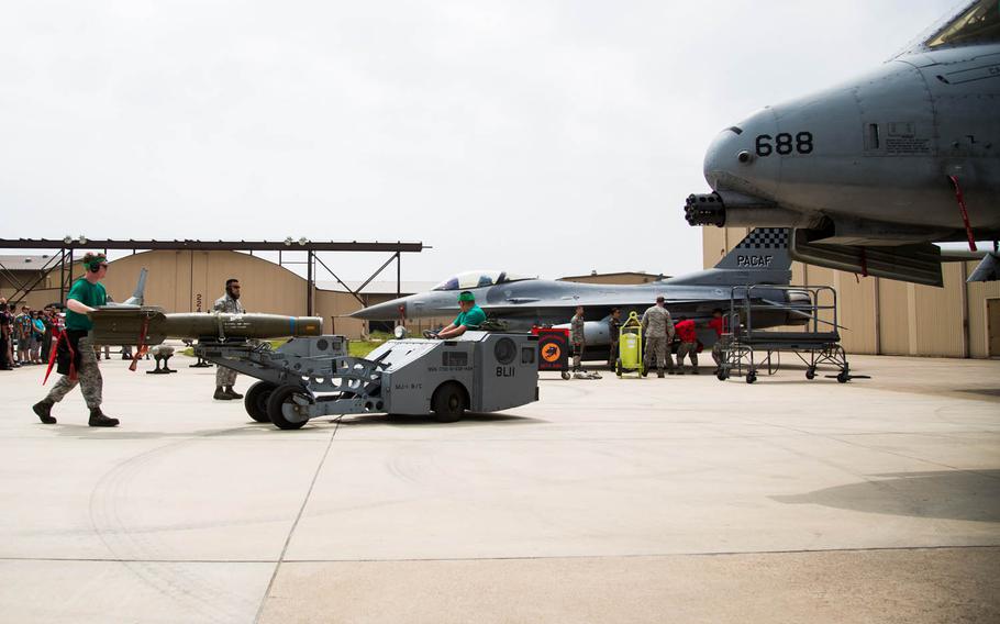 Competitors load a bomb onto a jet with a jammer during the 2017 Annual Load Crew Competition at Kunsan Air Base, South Korea, Saturday, May 13, 2017.
