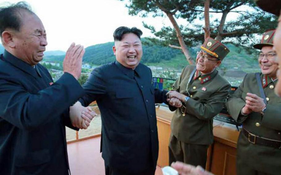 North Korean leader Kim Jong Un smiles as he apparently celebrates the test launch of a new type of missile, Sunday, May 14, 2017.