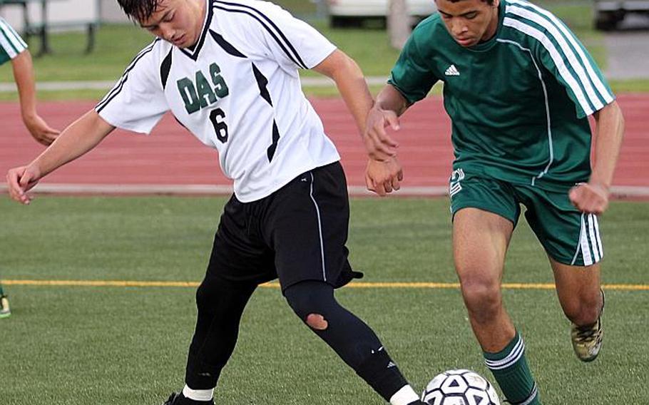 Daegu's Jacob Litton and Robert D. Edgren's Isaiah Robinson scuffle for the ball during Tuesday's pool-play match in the Far East Boys Division II Soccer Tournament, won by the Eagles 1-0. Robinson had the match's only goal. CAITLIN BLOUNT/SPECIAL TO STRIPES