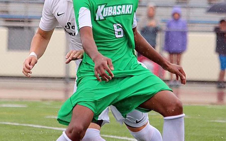 Splish-splash! Kubasaki's Jeffrey Horton tries to dribble the ball against Seoul American and through standing water on the field during Tuesday's round-robin match in the Far East Boys Division I Soccer Tournament, won by defending champion Dragons 5-1. KATRICIA AQUINO/SPECIAL TO STRIPES
