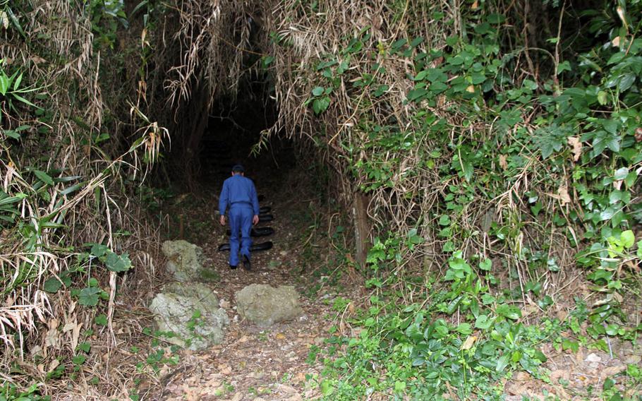 A Japan Maritime Self-Defense Force sailor begins the long journey up to one of the Heshikiya community's most sacred sites at a U.S. military installation on Okinawa.