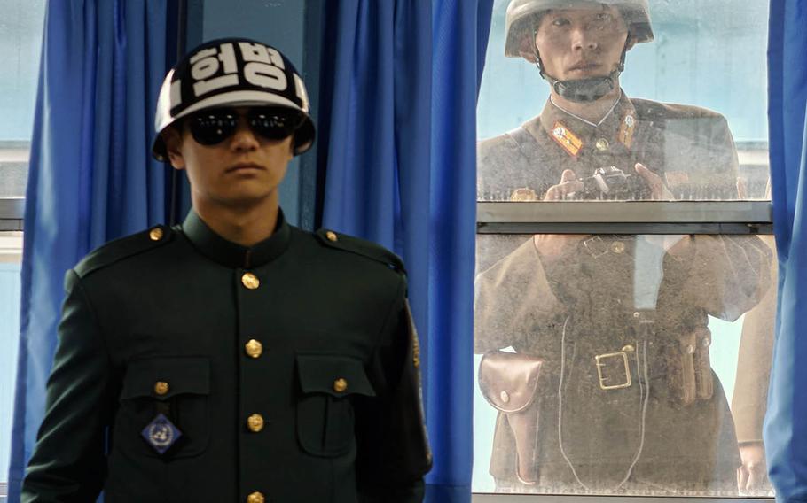 A North Korean soldier looks over the shoulder of a South Korean soldier inside the United Nations Command Military Armistice Commission Conference Building at the Joint Security Area of the Demilitarized Zone between North and South Korea, in November 2015. 
