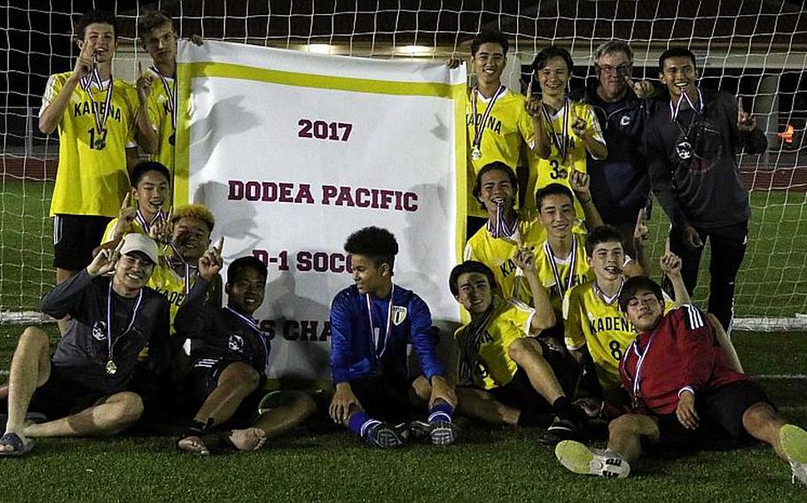 Kadena players gather round the banner after their 1-0 win Wednesday over defending champion Kubasaki, the Panthers' third Far East Boys Division I Soccer Tournament title in five years. MARY OBSUNA/SPECIAL TO STRIPES