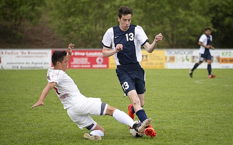 Kaiserslautern's Jonathan Millet, left, slides to stop Lakenheath's Riley Fleming during the DODEA-Europe soccer tournament in Reichenbach, Germany, on Thursday, May 18, 2017. Kaiserslautern won the Division I match 5-0 and advanced to the semifinals. MICHAEL B. KELLER/STARS AND STRIPES