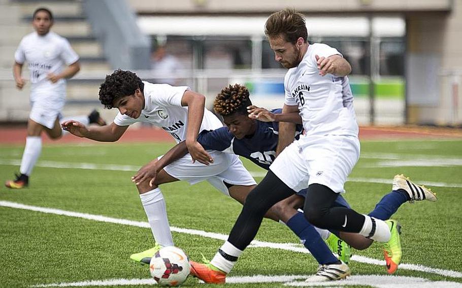 Bahrain's Hasan Admad, left, and Rashed Alkhoori run past Bitburg's J'Lynn Stevens during the DODEA-Europe soccer tournament in Kaiserslautern, Germany, on Thursday, May 18, 2017. Bahrain lost the Division II match 1-0. MICHAEL B. KELLER/STARS AND STRIPES
