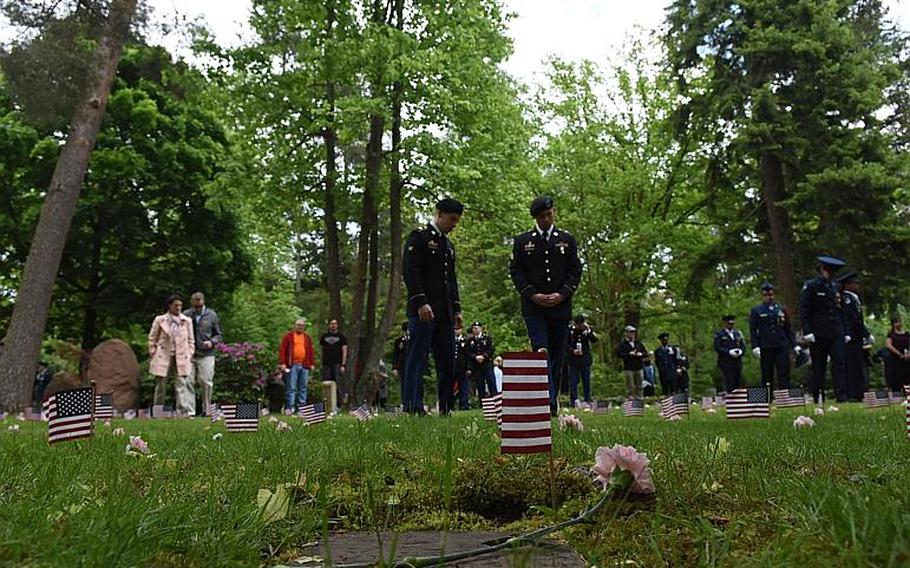 Military personnel and local community members walk among the Kindergraves on Saturday, May 20, 2017, in Kaiserslautern, Germany. Germans and Americans remembered the 452 American children buried in the Kindergraves during an annual memorial ceremony.
                