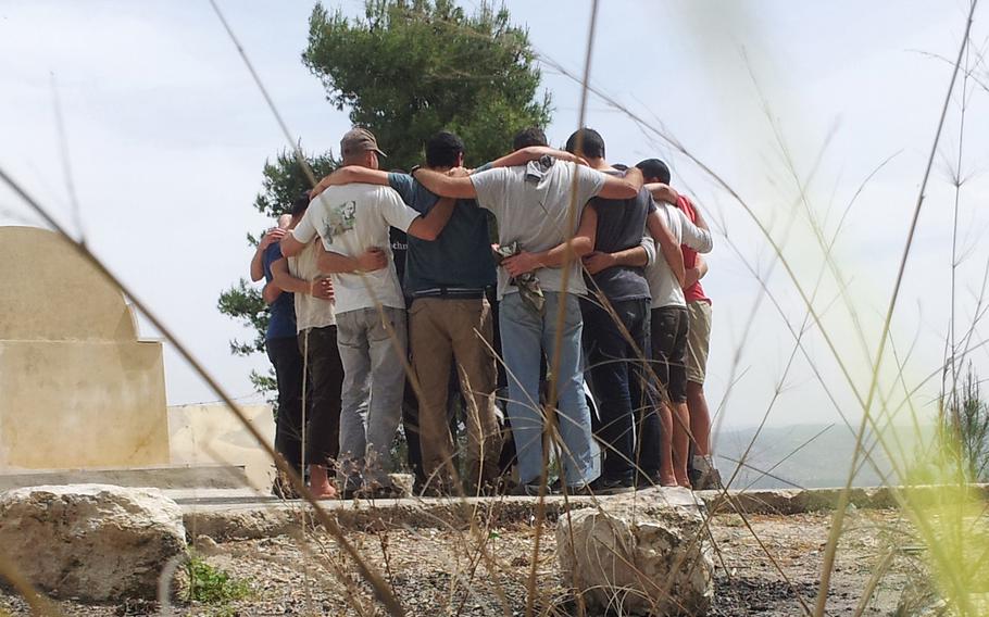 A former Israeli special operations team tgathers as a group for a private moment along Israel's Mediterranean coastline during their participation in the Peace of Mind program which treats full special operations units for post-combat trauma.