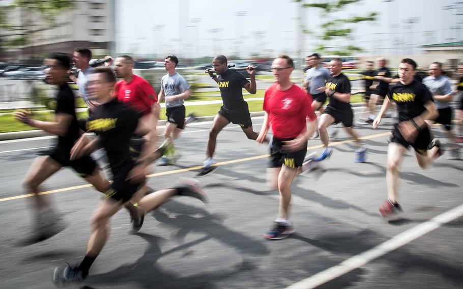 Soldiers race a 5K while carrying .50-caliber machine gun barrels during the 1st Armored Brigade Combat Team, 1st Infantry Division's centennial celebration at Camp Humphreys, South Korea, Wednesday, May 24, 2017.