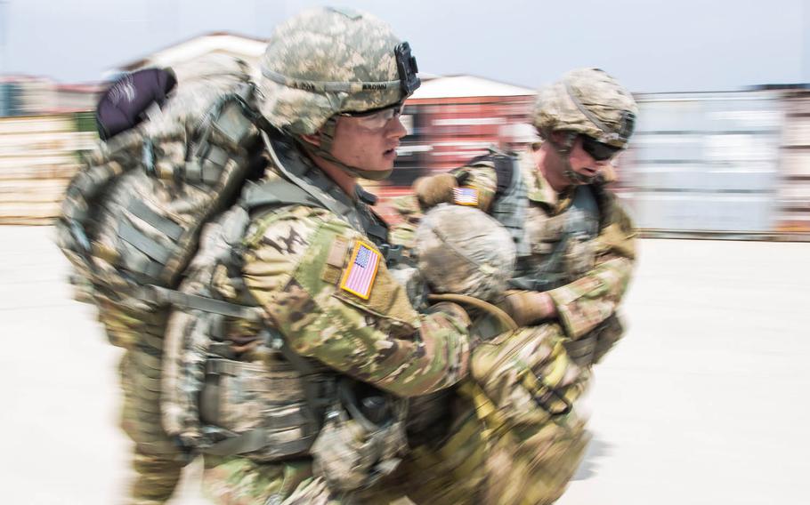 Soldiers carry a simulated casualty as part of a "Warrior Competition" during the 1st Armored Brigade Combat Team, 1st Infantry Division's centennial celebration at Camp Humphreys, South Korea, Wednesday, May 24, 2017.