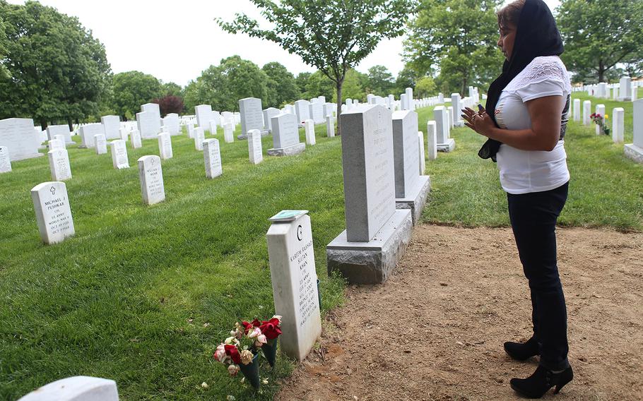 Gold Star Mother Sheba Khan prays at the grave of her son, Marine Cpl. Kareem Rashad Sultan Khan. 