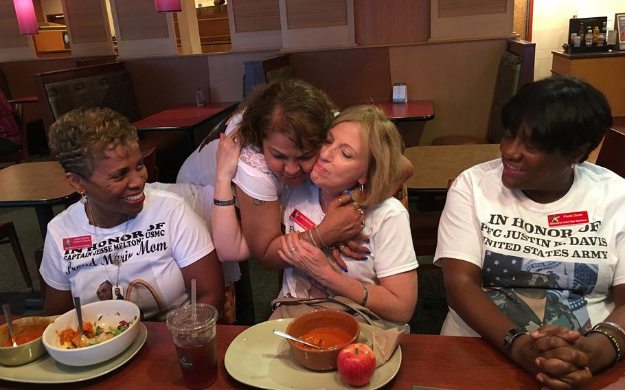 Sheba Khan, standing, hugs Gina Barnhurst, as fellow Gold Star Mothers Janice Chance, left, and Paula Davis, right, look on. The women are members of the Maryland chapter of American Gold Star Mothers Inc. Their sons were killed while fighting in Iraq and Afghanistan.