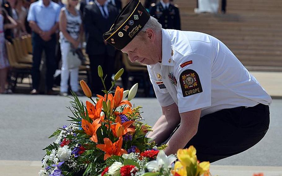 Alan Henrichson of Veteran's of Foreign Wars Post 27 presents a floral arrangement at the Memorial Day ceremony at Meuse-Argonne American Cemetery in Romagne-sous-Montfaucon, France, Sunday May 28, 2017.