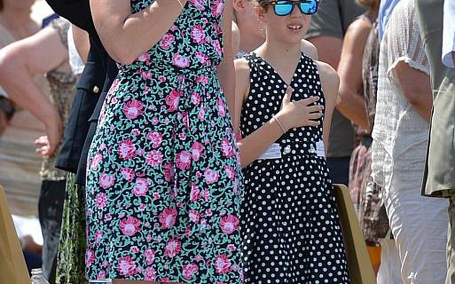 Kelly Lee and her daughter, Lauren, from Ramstein, Germany, hold their hands over their hearts during the playing of the national anthem the Memorial Day ceremony at Meuse-Argonne American Cemetery in Romagne-sous-Montfaucon, France, Sunday May 28, 2017.