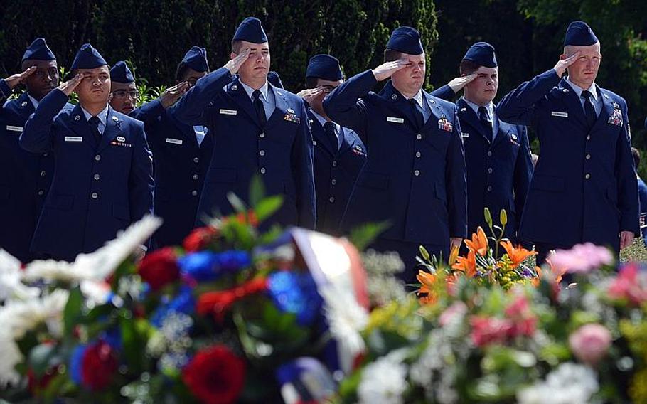 American volunteers from Ramstein Air Base salute during the playing of the French equivalent of ''Taps'' at the Memorial Day ceremony at Meuse-Argonne American Cemetery in Romagne-sous-Montfaucon, France, Sunday May 28, 2017.