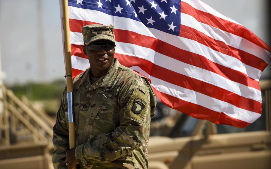 U.S. Army Staff Sgt. Anthony Miller with the 101st Airborne Division holds the American flag during a graduation ceremony for Somali soldiers, May 24, 2017, in Mogadishu, Somalia. The soldiers completed a course focused on various aspects of logistics.