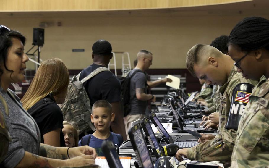 Brandy Madrigal, second from left, registers with wardens as her two children look on at the Noncombatant Evacuation Operation assembly point on Camp Humphreys, South Korea, June 5, 2017, during a semiannual evacuation drill known as Focused Passage.