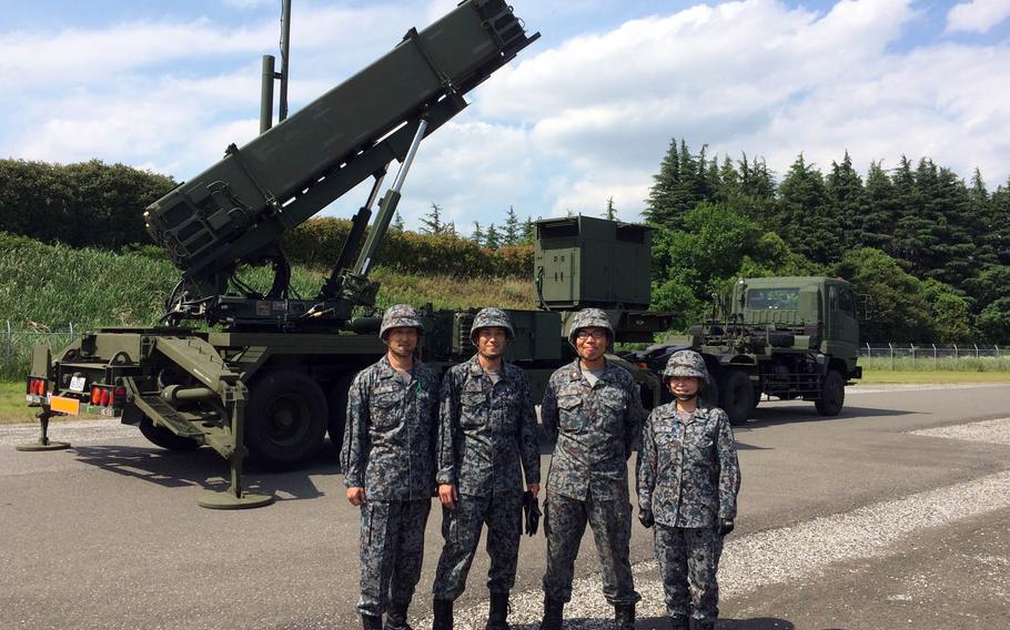 Members of Japan's 1st Air Defense Missile Group pose with a PAC3 launcher at Iruma Air Base on the outskirts of Tokyo, Friday, June 9, 2017.