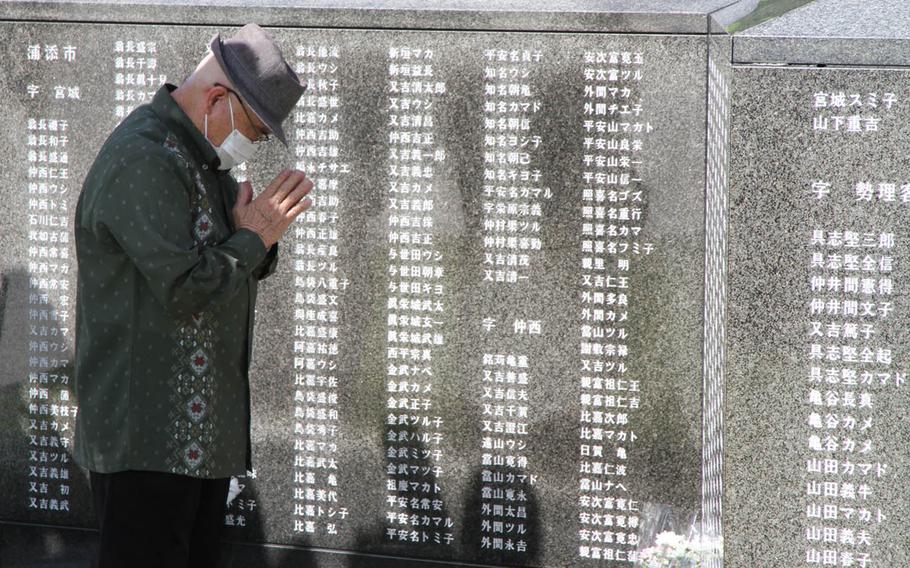 An Okinawan mourns for lost relatives during the Irei no Hi ceremony at Okinawa Peace Memorial Park in Naha, Okinawa, Friday, June 23, 2017.