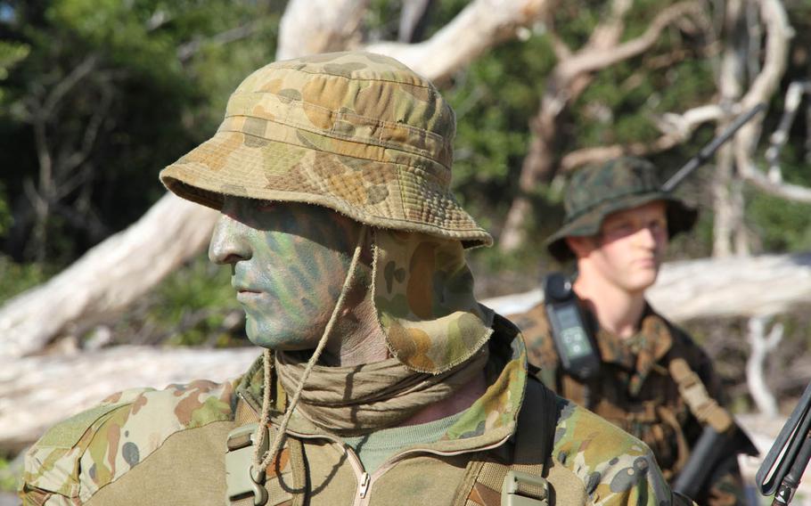 Australian Army Cpl. Bradley Congerton, foreground, watches Marines from Okinawa-based 31st Marine Expeditionary Unit come ashore during an amphibious assault at Shoalwater Bay Training Area, Australia, Wednesday, July 19, 2017.