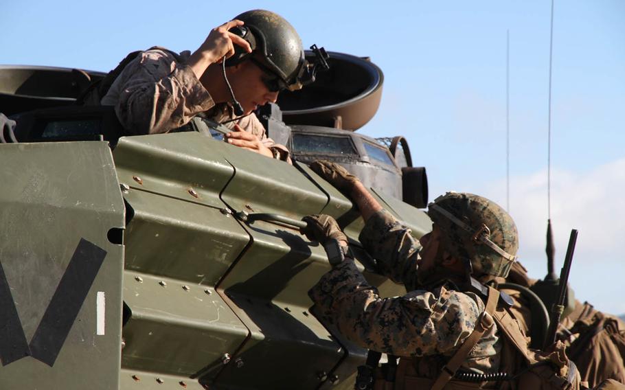 A Marine from the 31st Marine Expeditionary Unit climbs up an amphibious assault vehicle that has just reached Freshwater Beach in Queensland, Australia, Wednesday, July 19, 2017. The joint U.S.-Australian amphibious assault was part of Talisman Saber 2017 exercises.