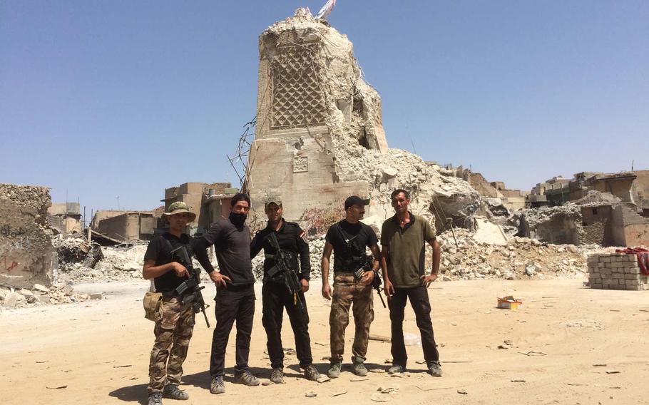 Iraqi troops at the base of al-Hadba, Mosul's famous leaning minaret, on Thursday, July 20, 2017. The minaret and the Great Mosque of al-Nuri were blown up by the Islamic State group last month.